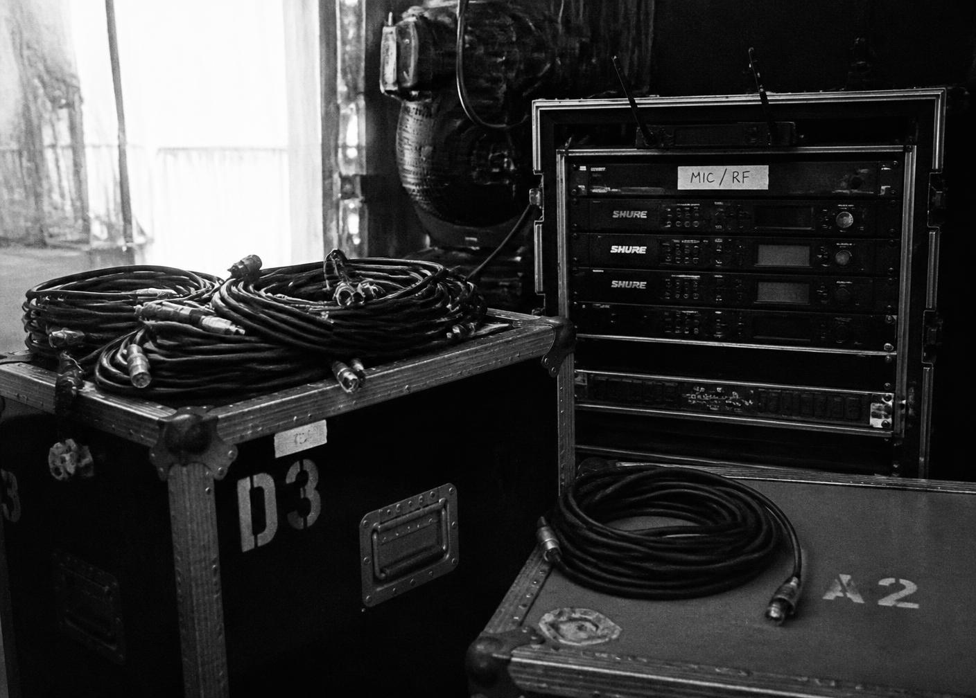 Backstage road cases, cable runs and wireless microphone rack